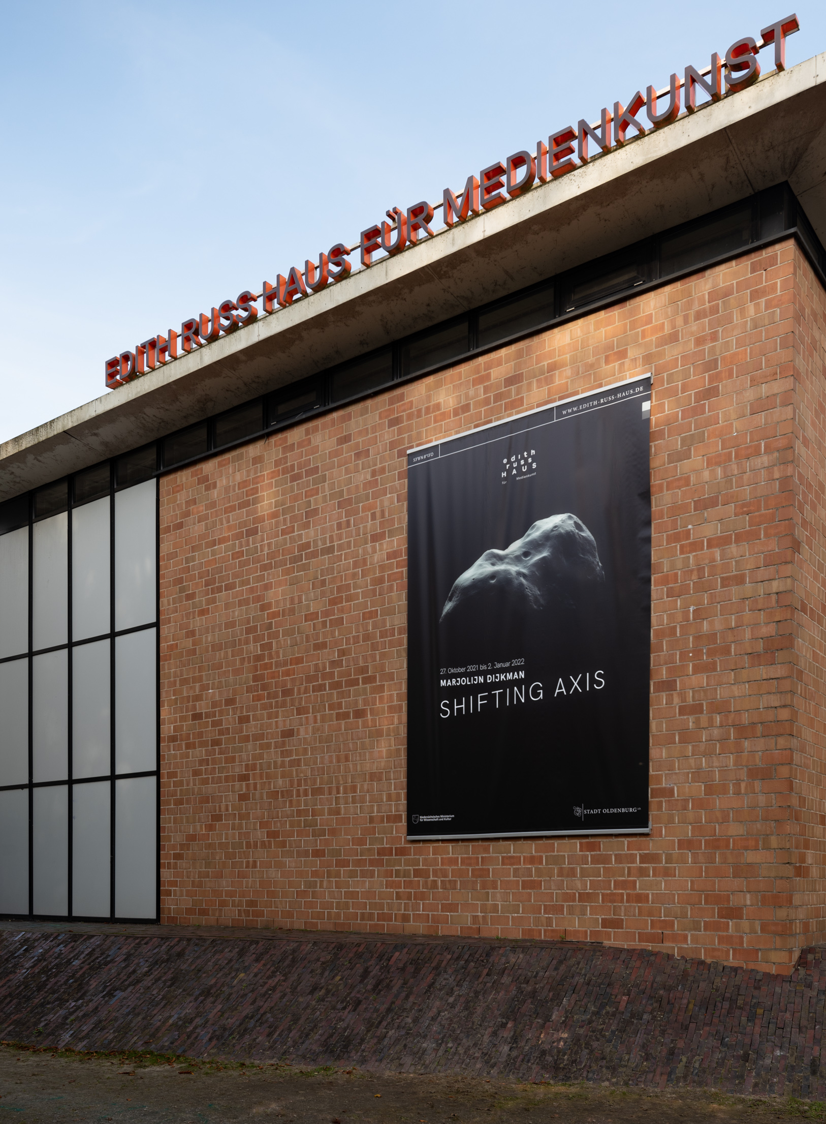 Das Foto zeigt die Fassade des Edith-Russ-Hauses mit dem Banner zur Ausstellung Marjolijn Dijkman: Shifting Axis. Foto © Edith-Russ-Haus